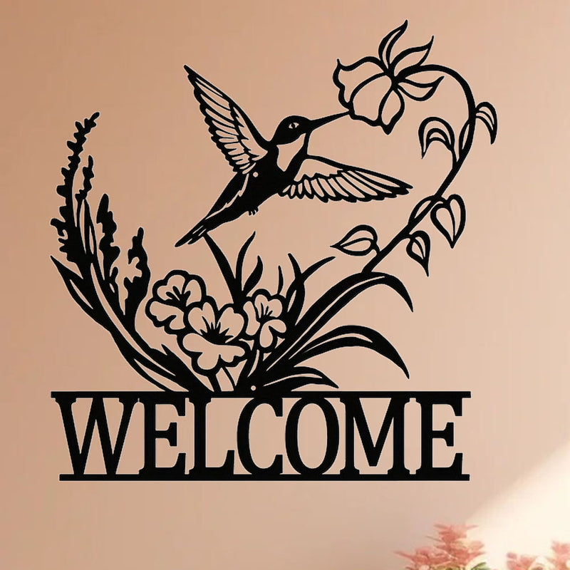 Metal hummingbird welcome sign shown at scale on a wall